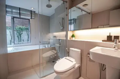 a bathroom with a toilet and a sink and a shower at Destiny55 Thonglor Apartment in Bangkok