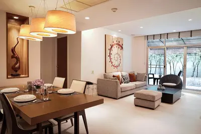 a dining room and living room with a table and chairs at Destiny55 Thonglor Apartment in Bangkok
