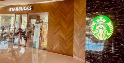 a shopping mall with a starbucks sign on a wall at Alt Hotel Nana by UHG in Bangkok