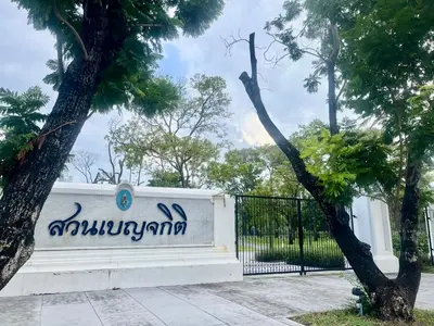 a white fence with writing on it next to a tree at Alt Hotel Nana by UHG in Bangkok