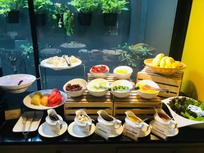 a buffet of food with bowls of fruits and vegetables at Alt Hotel Nana by UHG in Bangkok