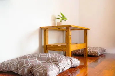 a room with a bed and a table with a plant on it at Alley & Pier in Bangkok