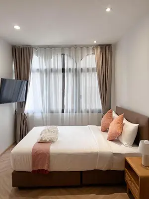 a bedroom with a large bed in front of a window at SO Zen Hotel Silom Bangkok in Bang Rak