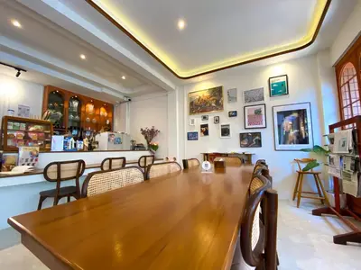a dining room with a long wooden table and chairs at SO Zen Hotel Silom Bangkok in Bang Rak