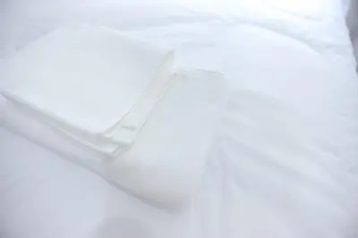 a white bowl sitting on top of a bed at G5 Hostel in Bangkok