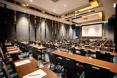 a large room with tables and chairs and a projection screen at Frame Hotel Bangkok in Bangkok