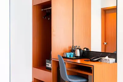 a wooden desk with a blue chair in a room at Frame Hotel Bangkok in Bangkok