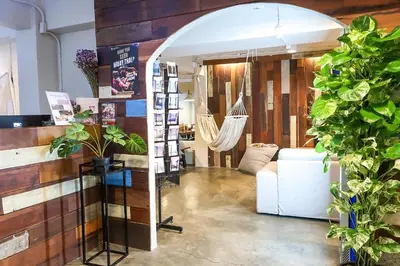 a living room with a hammock in the middle of a room at Qilombo Hostel Silom in Bangkok