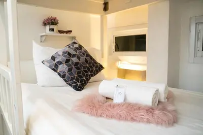 a room with a bed with towels and a pillow at Qilombo Hostel Silom in Bangkok