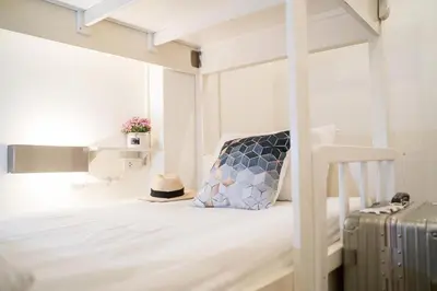 a bedroom with a bunk bed with a suitcase at Qilombo Hostel Silom in Bangkok