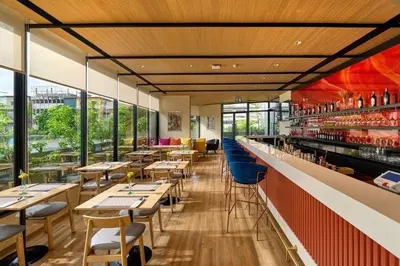 a restaurant with tables and chairs and a bar at MO Hotel Bangkok in Bangkok