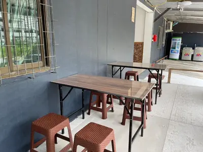 a row of tables and chairs in a room at OYO 75577 Palace Hostel in Amphoe Phra Khanong