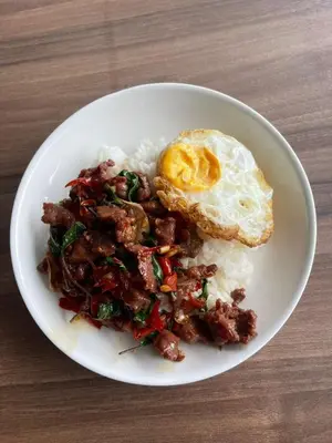 a plate of food with an egg and rice at OYO 75577 Palace Hostel in Amphoe Phra Khanong