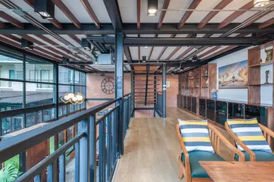 a room with a balcony with tables and chairs at Thananya Apartment in Amphoe Phra Khanong