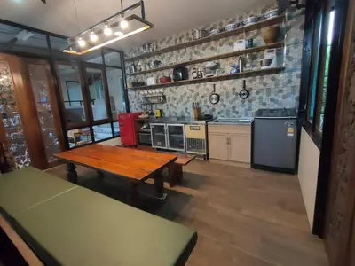 a large kitchen with a wooden table in a room at Thananya Apartment in Amphoe Phra Khanong