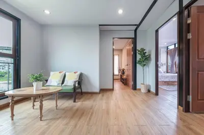 a living room with a table and a couch at Thananya Apartment in Amphoe Phra Khanong