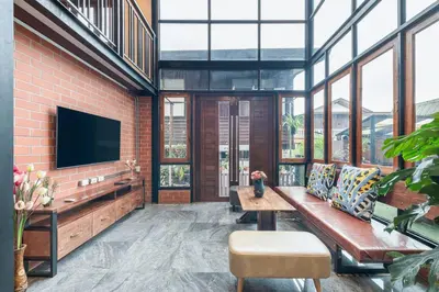a living room with a bench and a tv at Thananya Apartment in Amphoe Phra Khanong