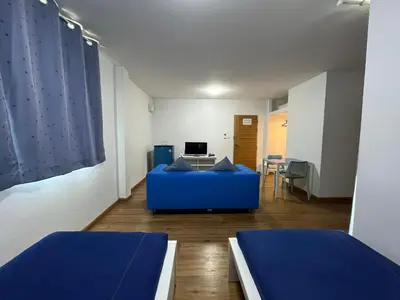 a living room with two beds and a blue couch at Dao Jaras Fah Hometel ดาวจรัสฟ้าโฮมเทล in Bangkok