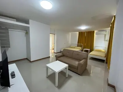 a living room with a couch and a bed at Dao Jaras Fah Hometel ดาวจรัสฟ้าโฮมเทล in Bangkok