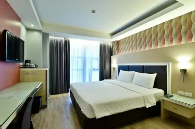 a hotel room with a bed and a television at Prestige Suites Nana in Bangkok