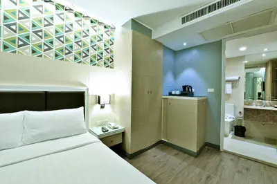 a hotel room with a bed and a bathroom at Prestige Suites Nana in Bangkok