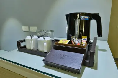 a counter top with a coffee maker and some candles at Prestige Suites Nana in Bangkok