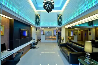 a lobby of a hotel with a couch and a tv at Prestige Suites Nana in Bangkok