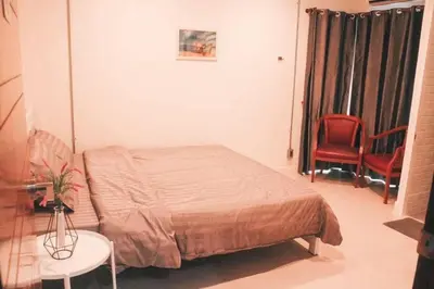 a bedroom with a bed and two red chairs at Jira19Hostel in Bangkok