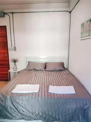 a bed in a room with two white towels on it at Jira19Hostel in Bangkok