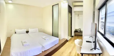 a bedroom with a white bed and a television at ABC SO Hotel Bangkok in Bangkok
