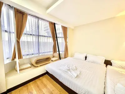 a bedroom with a bed and a large window at ABC SO Hotel Bangkok in Bangkok