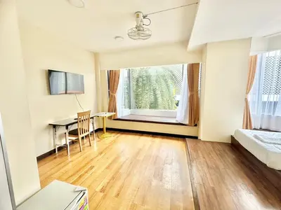 a bedroom with a desk and a bed and a window at ABC SO Hotel Bangkok in Bangkok