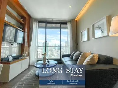a living room with a couch and a large window at Grand Modern 2BR - Ultra Fast WiFi - Phrom Phong in Bangkok