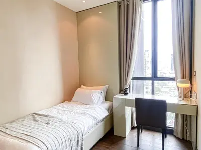 a bedroom with a bed and a desk and a window at Grand Modern 2BR - Ultra Fast WiFi - Phrom Phong in Bangkok