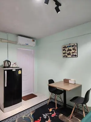 a kitchen with a table and a refrigerator and chairs at 812 Quiet AC Apartment with Balcony & free Wifi in Bangkok