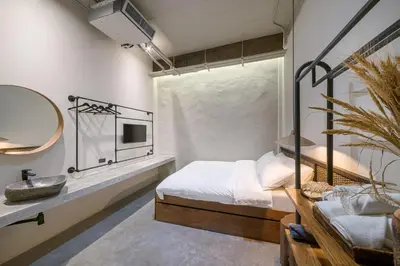 a bedroom with a bed and a sink and a mirror at Siam Shelter Bangkok in Bangkok