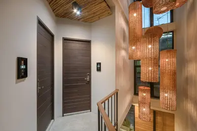 a hallway with a wooden door and chandeliers at Siam Shelter Bangkok in Bangkok
