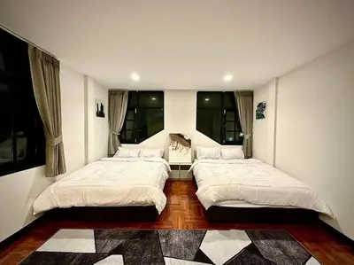 two beds in a room with two windows at Number3 Poolvilla Bangkok in Lat Krabang