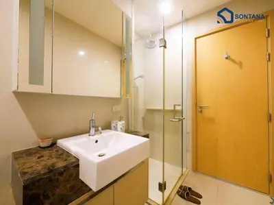 a bathroom with a sink and a glass shower at Expansive Modern - BTS Phrom Phong - Ultra Fast WiFi in Khlong Toei
