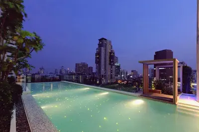 a swimming pool with a city skyline in the background at Expansive Modern - BTS Phrom Phong - Ultra Fast WiFi in Khlong Toei