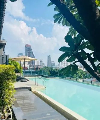 a large swimming pool with a city in the background at Serene home in the heart of BKK - The Great Wave in Bangkok