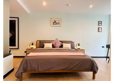 a bedroom with a large bed with two lamps at Serene home in the heart of BKK - The Great Wave in Bangkok