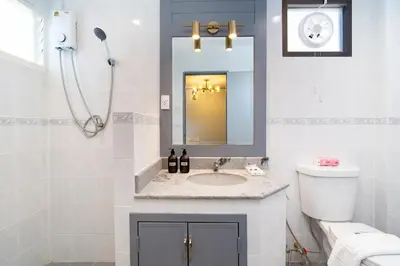 a bathroom with a sink and a toilet and a mirror at Capitel Rama 4 in Bangkok