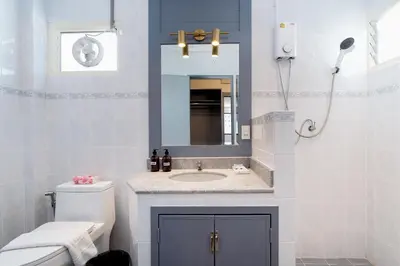 a bathroom with a sink and a toilet and a mirror at Capitel Rama 4 in Bangkok