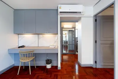 a kitchen with blue cabinets and a chair in a room at Capitel Rama 4 in Bangkok