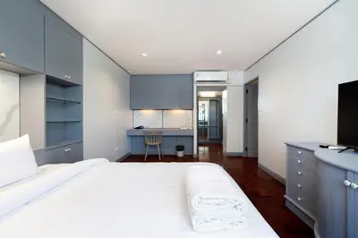 a bedroom with a large white bed and blue cabinets at Capitel Rama 4 in Bangkok