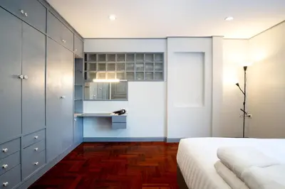 a bedroom with a white bed and a blue cabinet at Capitel Rama 4 in Bangkok