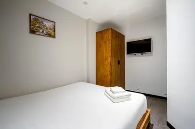 a bedroom with a white bed and a tv at XX GO INN Sukhumvit-Bts Asoke-Phrom Phong โกอินน์ สุขุมวิท in Bang Kapi