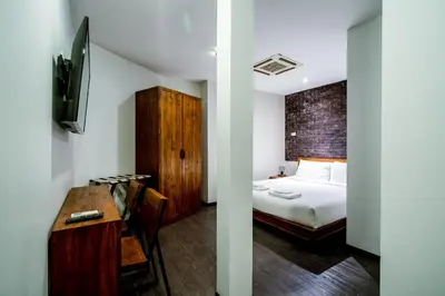 a bedroom with a bed and a desk with a desk at XX GO INN Sukhumvit-Bts Asoke-Phrom Phong โกอินน์ สุขุมวิท in Bang Kapi