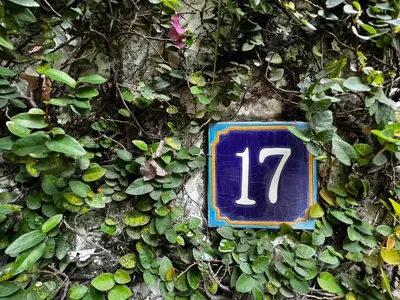 a blue sign with the number on a wall at The Backyard 28 in Khlong Toei